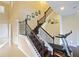 Staircase with dark wood steps, detailed black iron railing, and artwork, leading to the upper level of the home at 3687 Farm Bell Pl, Lake Mary, FL 32746
