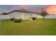 A well-manicured backyard with a lush green lawn, a small patio and a white fence in the distance at 3807 Night Heron Dr, Sanford, FL 32773