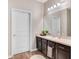 Bathroom featuring a vanity with dark wood cabinets, cream countertop and a large mirror with modern light fixture at 3807 Night Heron Dr, Sanford, FL 32773