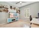 Spare bedroom with floating shelves with glass bottles on display and a white desk at 3807 Night Heron Dr, Sanford, FL 32773