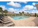 A community pool area with lounge chairs surrounding the pool and palm trees in the background at 3807 Night Heron Dr, Sanford, FL 32773
