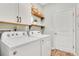 Functional laundry room with a full-size washer, dryer, and overhead storage at 3807 Night Heron Dr, Sanford, FL 32773