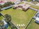 Expansive aerial view showcases a home with a large fenced yard and outdoor entertaining space at 385 Woodland Ave, Daytona Beach, FL 32118