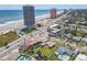 Expansive aerial view of a coastal community with beachfront condos and single-Gathering homes near the ocean at 385 Woodland Ave, Daytona Beach, FL 32118