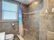 Tiled shower in bathroom featuring an adjustable shower head and beach themed curtain at 385 Woodland Ave, Daytona Beach, FL 32118