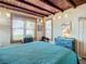Cozy bedroom featuring wood ceilings, a blue quilt, and desk area by the windows at 385 Woodland Ave, Daytona Beach, FL 32118