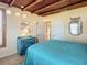 Inviting bedroom with wood beam ceilings, tile floors, and a colorful blue dresser at 385 Woodland Ave, Daytona Beach, FL 32118
