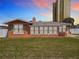 Quaint single-story home with a colorful exterior, bright windows, and decorative surfboard accents at 385 Woodland Ave, Daytona Beach, FL 32118