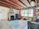 Inviting living room with a stone fireplace, wood-beam ceiling, and plenty of natural light at 385 Woodland Ave, Daytona Beach, FL 32118