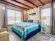 Comfortable main bedroom with beamed ceilings, tile floors, ample natural light, and calming decor at 385 Woodland Ave, Daytona Beach, FL 32118