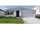 Charming single-story home with a two-car garage, complemented by green grass and landscaping at 3925 Diving Dove Ln, Bartow, FL 33830