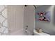 Tiled bathroom features a shower/tub, toilet, and fun decor on the wall at 400 E Orlando Ave # 10 C, Ocoee, FL 34761