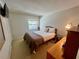 Bedroom with a side table, dresser, window, and a cozy queen-sized bed at 400 E Orlando Ave # 10 C, Ocoee, FL 34761