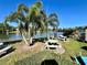 Lakeside picnic area with stone tables and benches, barbecue grills, and shade provided by several palm trees at 400 E Orlando Ave # 10 C, Ocoee, FL 34761