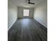 Spacious living room with dark wood-look flooring and a ceiling fan at 403 Britten Dr, Kissimmee, FL 34758