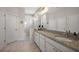 Stylish bathroom featuring double sinks, granite counters, and a glass enclosed walk-in shower at 4439 Davos Dr, Clermont, FL 34711