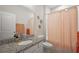 Well-lit bathroom with granite countertop, and a shower with coral accents at 4439 Davos Dr, Clermont, FL 34711