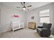 Cozy Bedroom with a crib, changing table, gray armchair, and natural light at 4439 Davos Dr, Clermont, FL 34711