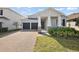 Charming home featuring a two-car garage, a well-maintained yard, and stone pillar details on the front porch at 4439 Davos Dr, Clermont, FL 34711