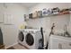 Convenient laundry room with white washer, dryer, sink, and storage at 4439 Davos Dr, Clermont, FL 34711