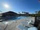 Community pool with lounge chairs, palm trees, and a sunny sky, offering a resort-like experience at 4439 Davos Dr, Clermont, FL 34711