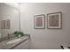 Bright powder room with granite countertop, framed art, and decorative greenery at 4439 Davos Dr, Clermont, FL 34711