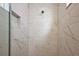 Modern shower featuring marble tile walls, rainfall shower head, and built-in shelving at 4439 Davos Dr, Clermont, FL 34711