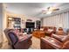 Cozy living room with brown leather seating and built-in bookcases at 4451 Seawater Street, Orlando, FL 32812