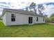 A single story home's backyard shows a well maintained lawn and sliding glass doors at 4765 Sw 128Th St, Ocala, FL 34473