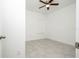 Bright bedroom featuring neutral tile flooring, white walls, a window with blinds, and a modern ceiling fan at 4765 Sw 128Th St, Ocala, FL 34473