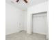 Bright bedroom featuring neutral tile flooring, white walls, a window with blinds, a ceiling fan, and a closet at 4765 Sw 128Th St, Ocala, FL 34473