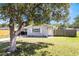 Inviting single-story home with a large tree providing shade, complemented by a neatly kept lawn at 4915 Pocahontas Ln, Lakeland, FL 33810