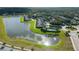 Picturesque aerial view of a lake with waterfront townhomes and community pool at 6024 Soter Ln, Windermere, FL 34786