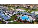 Stunning aerial view of a townhome with solar panels, a community pool, and a scenic pond at 6024 Soter Ln, Windermere, FL 34786