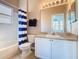 Functional bathroom with a tub, vanity, and window, featuring a blue and white striped shower curtain at 631 Tuscan Hills Blvd, Davenport, FL 33897