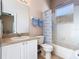 Well-lit bathroom featuring a single sink vanity, toilet, and a shower-tub combination with a curtain at 631 Tuscan Hills Blvd, Davenport, FL 33897