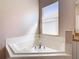 Large, tiled bathtub with modern fixtures and window offering natural light at 631 Tuscan Hills Blvd, Davenport, FL 33897