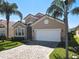 Exterior of a home with a tile roof, a two-car garage, and meticulously maintained lawn and palm tree landscaping at 631 Tuscan Hills Blvd, Davenport, FL 33897