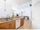 Kitchen with breakfast bar overlooking living areas, wood cabinets, and white appliances offering seamless entertaining at 631 Tuscan Hills Blvd, Davenport, FL 33897