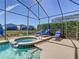 Sparkling pool with an attached spa, set within a screened enclosure and comfortable lounge chairs at 631 Tuscan Hills Blvd, Davenport, FL 33897
