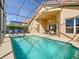 Inviting pool and spa with a screened lanai, complemented by a covered patio with seating, creating an oasis at 631 Tuscan Hills Blvd, Davenport, FL 33897