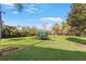 Expansive backyard featuring lush green grass, mature trees, and a trampoline, offering space for outdoor enjoyment at 743 Mills Estate Pl, Chuluota, FL 32766