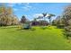 Spacious backyard with lush greenery, mature trees, and a screened lanai offers a perfect setting for relaxation and recreation at 743 Mills Estate Pl, Chuluota, FL 32766