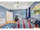 Comfortable bedroom features a ceiling fan, a workstation, and blue walls, creating a cozy and productive space at 743 Mills Estate Pl, Chuluota, FL 32766