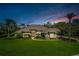 Charming home with lush lawn, mature trees and elegant details under a dramatic dusk sky at 743 Mills Estate Pl, Chuluota, FL 32766