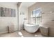 This bathroom features an elegant soaking tub under a window and sleek tile floors, creating a spa-like ambiance at 743 Mills Estate Pl, Chuluota, FL 32766