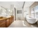 This bathroom features a soaking tub, modern vanity with granite countertop, and tile floors, all creating a relaxing space at 743 Mills Estate Pl, Chuluota, FL 32766
