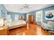 Spacious main bedroom features an accent chair, ensuite bathroom access, and wood flooring at 743 Mills Estate Pl, Chuluota, FL 32766