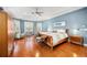 This main bedroom features light blue walls, tray ceiling, wood floors, accent chair, and bench seating for a spacious retreat at 743 Mills Estate Pl, Chuluota, FL 32766