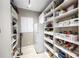 Well-organized pantry featuring ample shelving, storage baskets, and a white refrigerator for optimal space and convenience at 743 Mills Estate Pl, Chuluota, FL 32766
